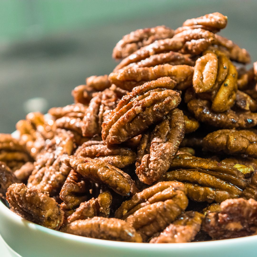 Barbecue pecan halves in a green bowl