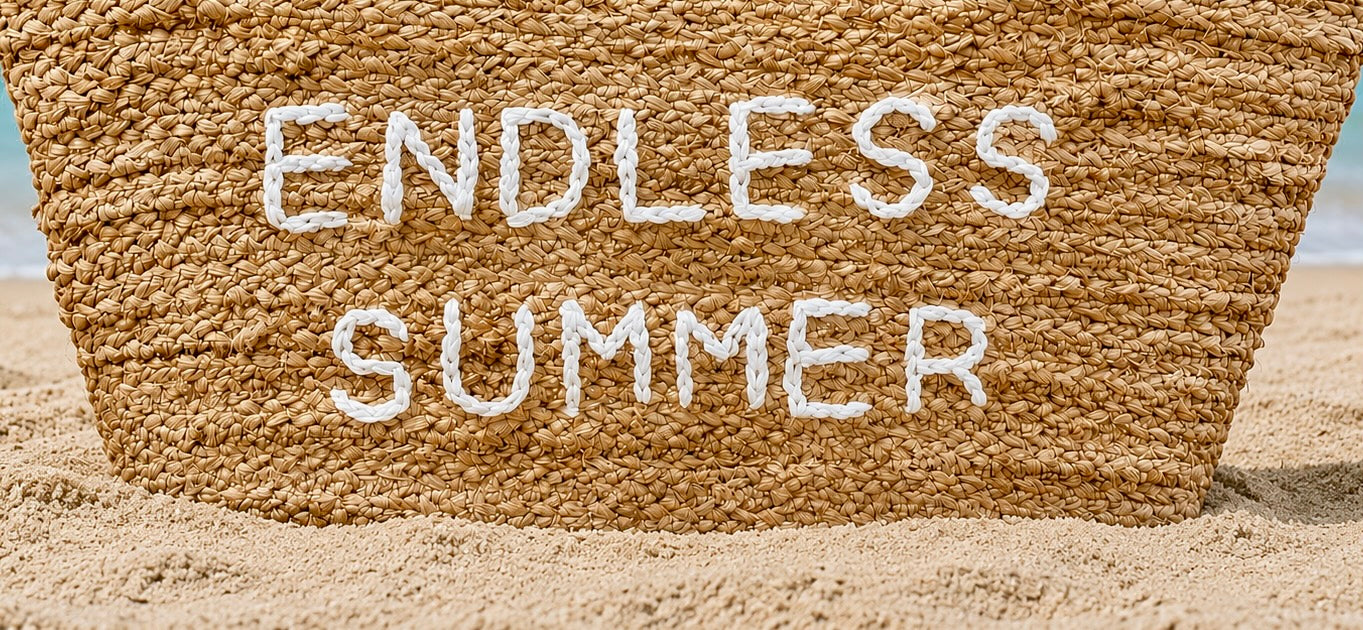 Beach Bag with phrase "Endless Summer" sitting on sand at the beach